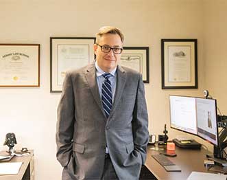photo of attorney Rick Stewart standing at desk